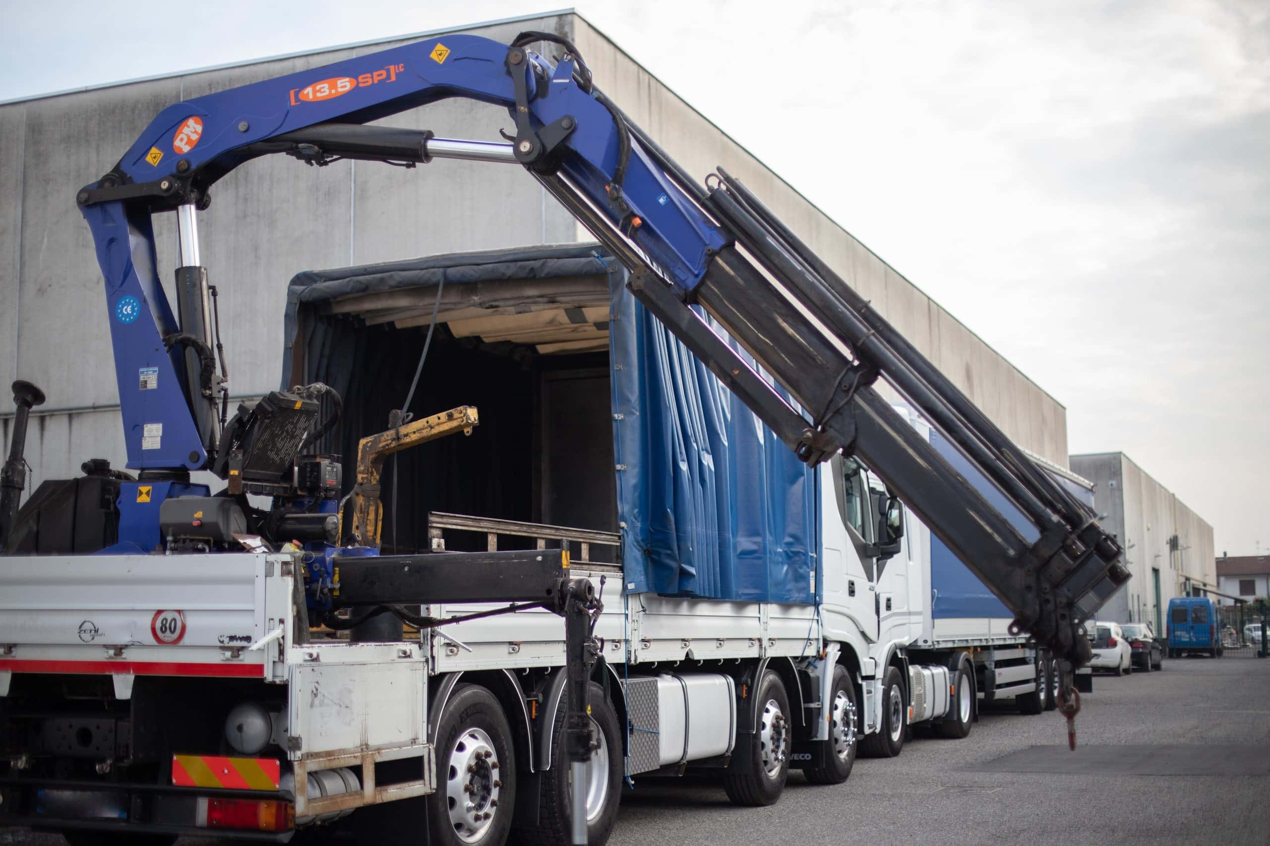 Gru radiocomandata in apertura sopra la motrice Iveco di La Masna Trasporti