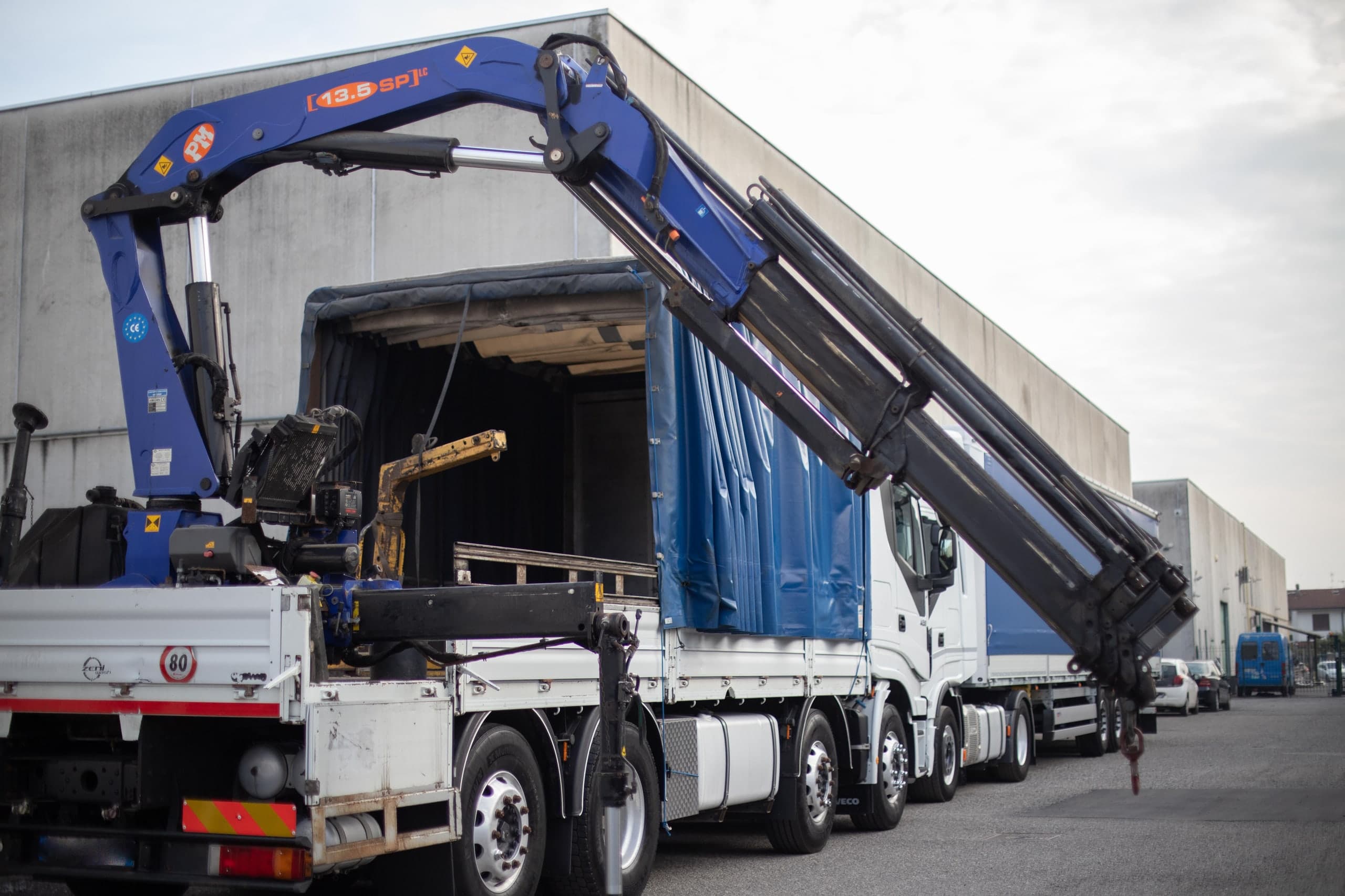 Gru radiocomandata PM 13.5 in apertura sopra la motrice Iveco di La Masna Trasporti