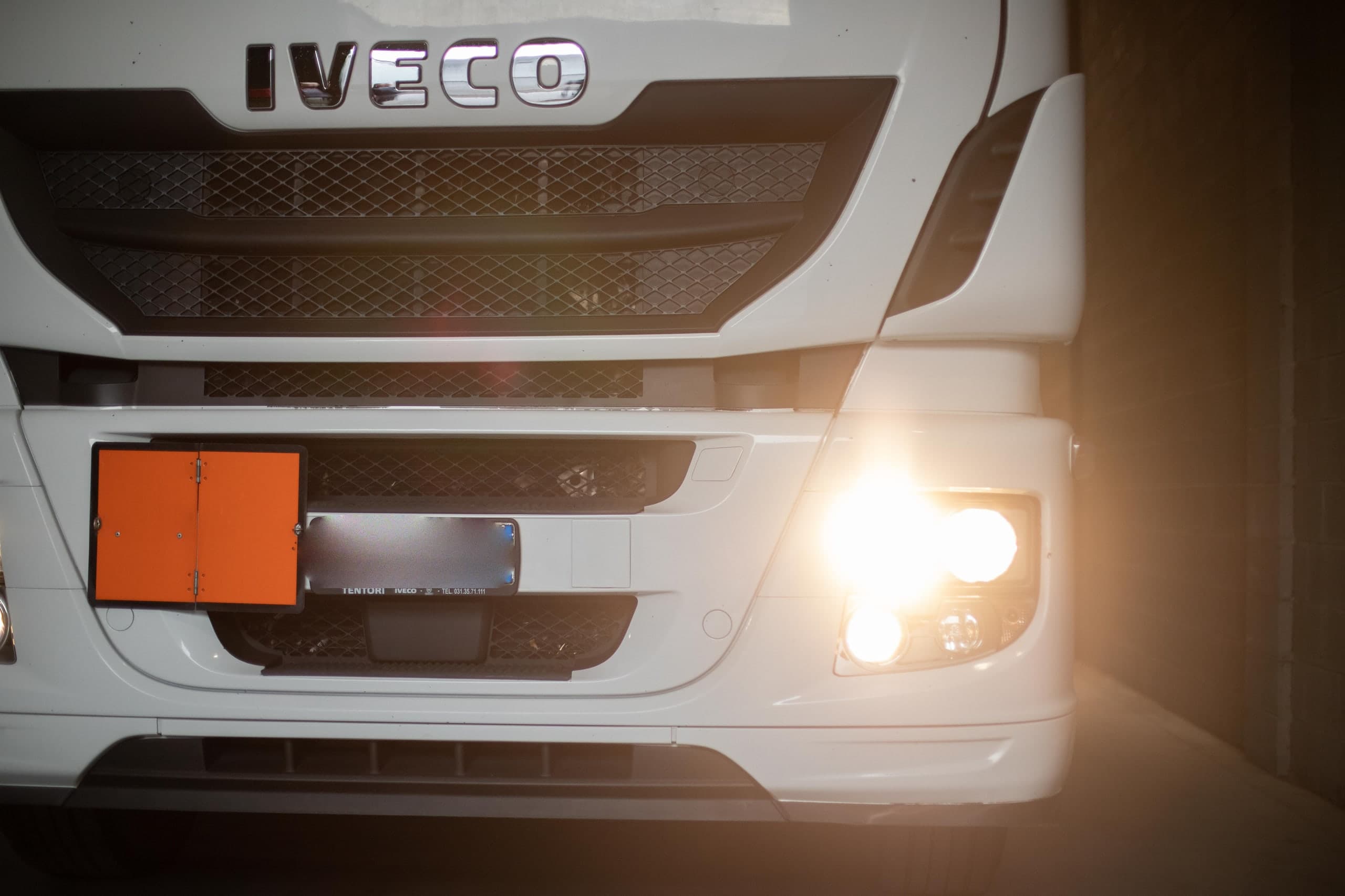 Frontale di una motrice Iveco con pannello arancio ADR nel deposito La Masna