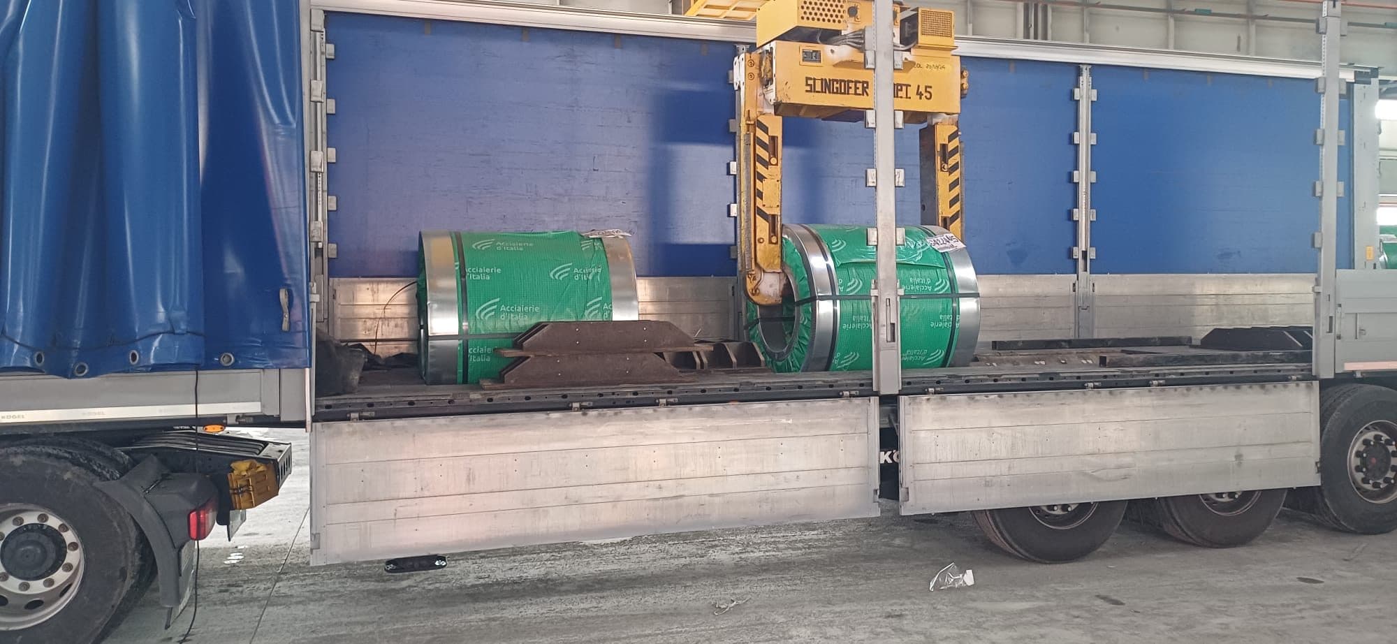 Due coils di acciaio adagiati nella culla portacoils del semirimorchio, fra gli appoggi sagomati sul piano di carico